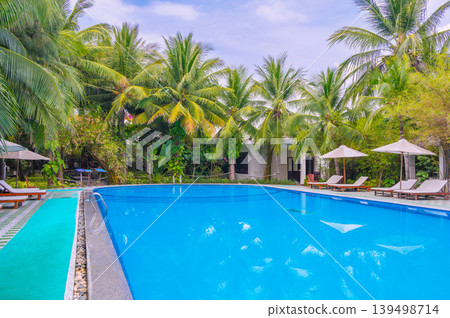 landscape with a swimming pool by palm trees in luxurious tropical resort in summer 139498714