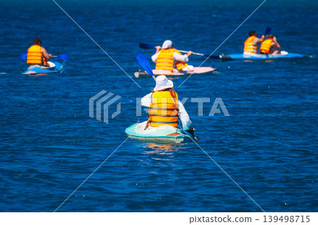 group of kayaker friends row and kayak on lake in summer on vacation group of kayaker friends row and kayak on lake in summer on vacation 139498715