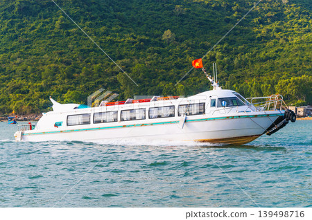 White tourist speedboat sails through sea near an island in Vietnam. Motor boat in river in Asia White tourist speedboat sails through sea near an island in Vietnam. Motor boat in river in Asia 139498716