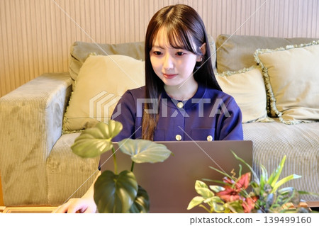 獨處的片刻寧靜。一位女性在輕鬆的空間裡享受上網和嗜好，這是她日常生活的一部分。 139499160