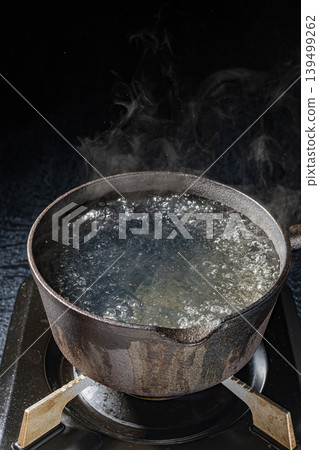 A cooking scene where hot steam rises from a pot of boiling water. A cooking scene where hot steam rises from a pot of boiling water. 139499262
