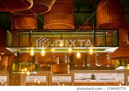 Artistic ceiling composition with wicker baskets and modern lighting. 139499776