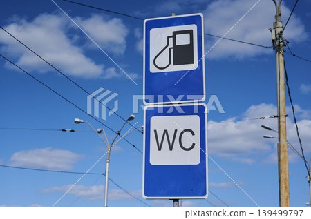 Fuel station sign indicating restroom availability under a bright blue sky Fuel station sign indicating restroom availability under a bright blue sky 139499797