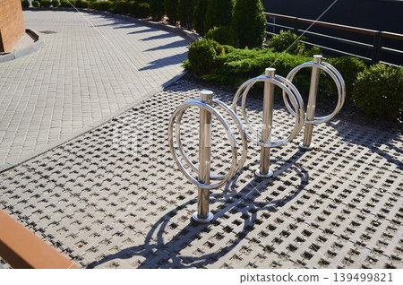 Unique bicycle parking design shines on a sunny day in a modern urban setting Unique bicycle parking design shines on a sunny day in a modern urban setting 139499821