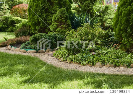 Lush garden pathway inviting exploration in bright afternoon sunlight and greenery Lush garden pathway inviting exploration in bright afternoon sunlight and greenery 139499824