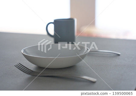 White dishes and cutlery placed on the table White dishes and cutlery placed on the table 139500065