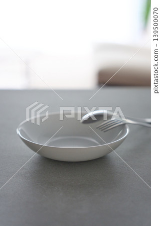 White dishes and cutlery placed on the table White dishes and cutlery placed on the table 139500070