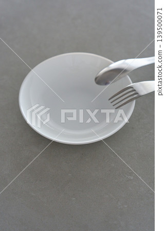 White dishes and cutlery placed on the table White dishes and cutlery placed on the table 139500071