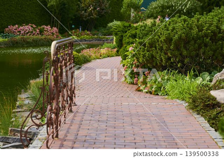 Serene garden pathway inviting peaceful strolls and nature's beauty 139500338