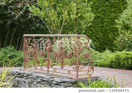 Beautiful decorative railing surrounded by lush greenery and elegant garden design 139500473