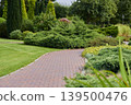 Serenity found in winding paths of a lush green garden near the city 139500476
