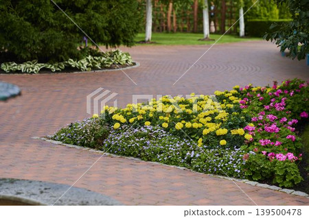 Colorful garden blooms brighten the winding pathway on a sunny day Colorful garden blooms brighten the winding pathway on a sunny day 139500478