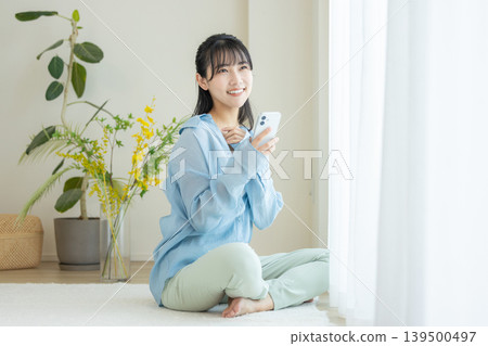 使用智能手機的少婦在屋子裡 139500497