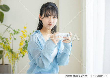 A woman watching a video on her smartphone A woman watching a video on her smartphone 139500505