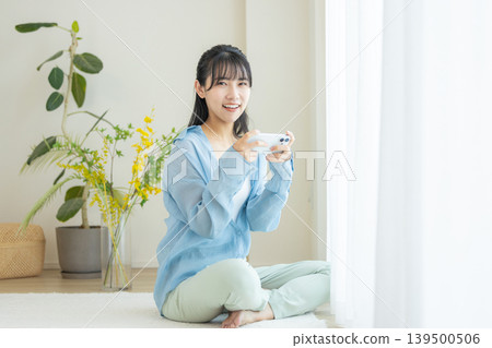 A woman watching a video on her smartphone A woman watching a video on her smartphone 139500506