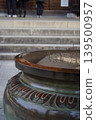 A magnificent incense burner with incense sticks placed in front of the stone steps of a shrine or temple. 139500957