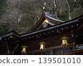 The magnificent roof and golden hanging lanterns of a historic shrine against a backdrop of withered trees. 139501010