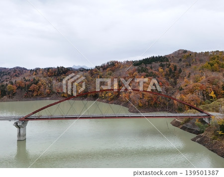 <Bird's-eye view> Red bridge, mountains with autumn foliage, and scenery reflected in the lake. <Bird's-eye view> Red bridge, mountains with autumn foliage, and scenery reflected in the lake. 139501387