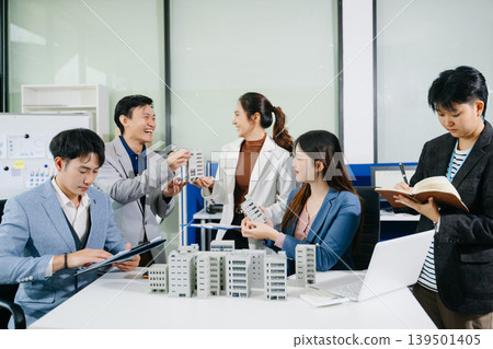Asian architect and business team discussing urban development projects in modern office, featuring teamwork, planning, collaboration Asian architect and business team discussing urban development projects in modern office, featuring teamwork, planning, collaboration 139501405