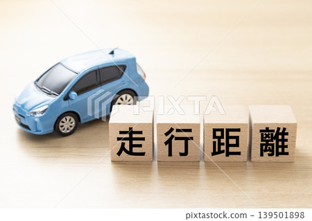 A block with "mileage" written on it and an eco-car A block with "mileage" written on it and an eco-car 139501898