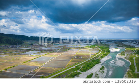 A cloudy May day, showing the Kurobe River alluvial fan and surrounding facilities such as Aimoto Bridge and parks, where it looks like it might rain. 139502319