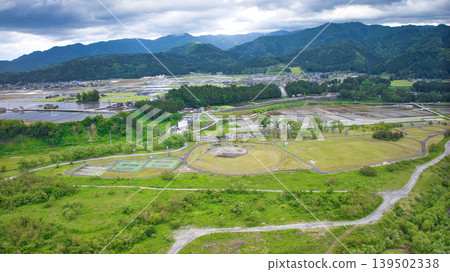 A cloudy May day, showing the Kurobe River alluvial fan and surrounding facilities such as Aimoto Bridge and parks, where it looks like it might rain. 139502338