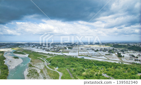 A cloudy May day, showing the Kurobe River alluvial fan and surrounding facilities such as Aimoto Bridge and parks, where it looks like it might rain. A cloudy May day, showing the Kurobe River alluvial fan and surrounding facilities such as Aimoto Bridge and parks, where it looks like it might rain. 139502340