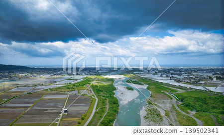 A cloudy May day, showing the Kurobe River alluvial fan and surrounding facilities such as Aimoto Bridge and parks, where it looks like it might rain. 139502341