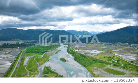 A cloudy May day, showing the Kurobe River alluvial fan and surrounding facilities such as Aimoto Bridge and parks, where it looks like it might rain. 139502354