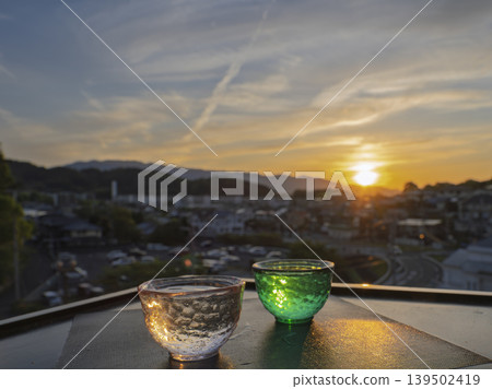 寧靜的黃昏。一邊品嚐美酒,一邊欣賞落日餘暉。 寧靜的黃昏。一邊品嚐美酒,一邊欣賞落日餘暉。 139502419