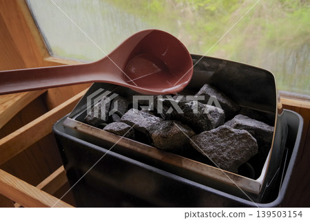 A heater in the sauna room that gives off a warm, woody feel. 139503154