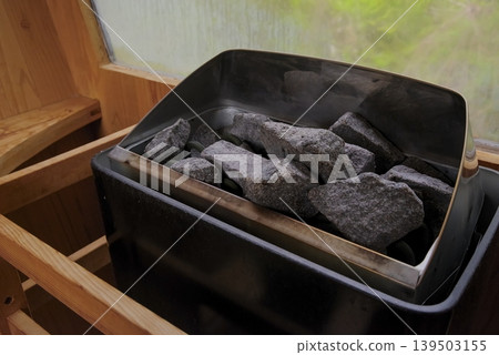 A heater in the sauna room that gives off a warm, woody feel. 139503155