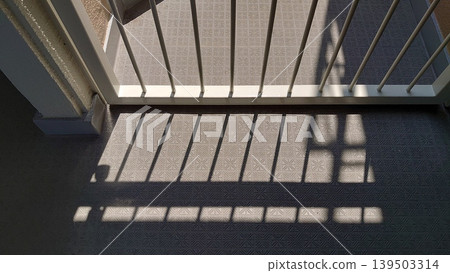The strong sunlight streaming onto the balcony and the shadows cast by the lattice The strong sunlight streaming onto the balcony and the shadows cast by the lattice 139503314