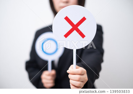 A businesswoman holding an "X" sign. 139503833