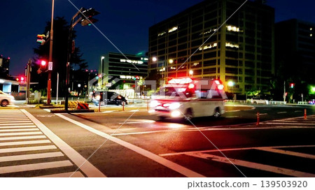 An ambulance speeding through an intersection at night. An ambulance speeding through an intersection at night. 139503920