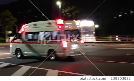 一輛救護車飛馳在漆黑的道路上。 一輛救護車飛馳在漆黑的道路上。 139503922