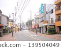 The road continues into the distance; it's a shopping street. 139504049