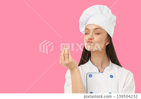 Woman in chef outfit making cooking gesture with hands Woman in chef outfit making cooking gesture with hands 139504232