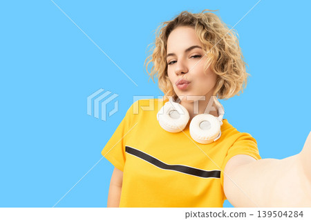Young woman poses for a selfie wearing headphones Young woman poses for a selfie wearing headphones 139504284