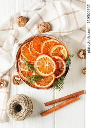 Dried orange slices arranged in a bowl on a table with nuts Dried orange slices arranged in a bowl on a table with nuts 139504305