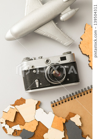 Camera and airplane model near travel-themed items on table Camera and airplane model near travel-themed items on table 139504311