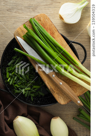 Fresh green onions are sliced on a wooden board Fresh green onions are sliced on a wooden board 139504319