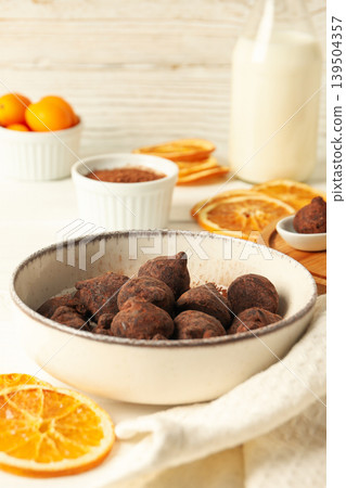 Chocolate truffles set on a white table with fruits and milk 139504357
