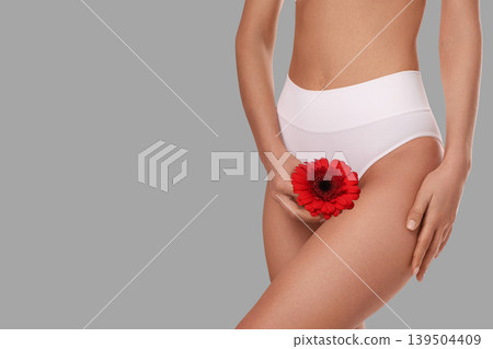 Woman gracefully holds flower enhancing her body care ritual 139504409