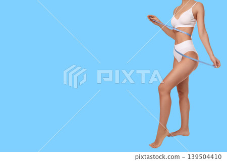 Female model measures waistline while promoting body care tips 139504410