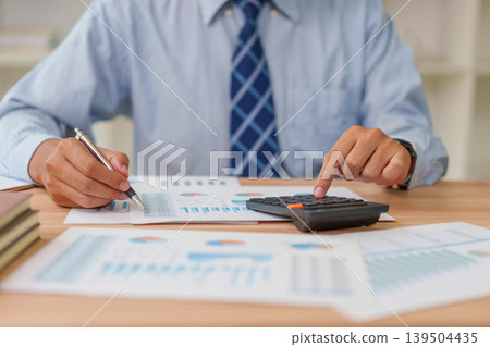 Asian Male 30-40s Real Estate Agent Analyzing Market Charts in Thailand Office 139504435