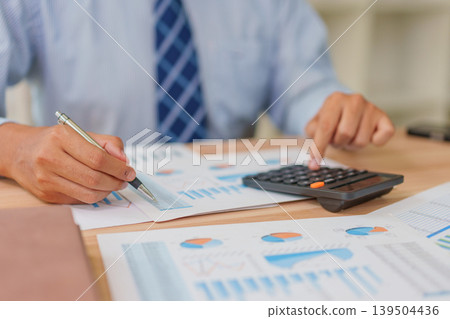 Asian Male 30-40s Real Estate Agent Analyzing Market Charts in Thailand Office Asian Male 30-40s Real Estate Agent Analyzing Market Charts in Thailand Office 139504436