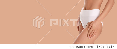 Woman prioritizes skincare and body confidence on beige background Woman prioritizes skincare and body confidence on beige background 139504517