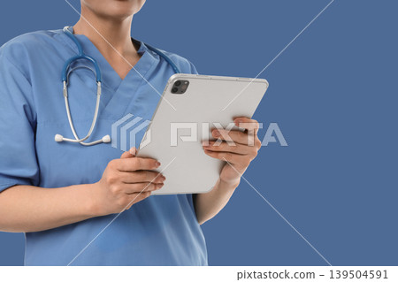 Healthcare worker engages with technology while assisting patients Healthcare worker engages with technology while assisting patients 139504591