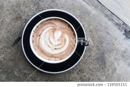 Top view of hot coffee macchiato or coffee latte with a natural background of tea plantations. 139505151